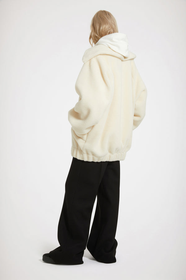 Patou - 재생 폴리에스터 소재의 인조 쉬어링 보머 재킷 - Avalanche - 순수한 쉬어링 감각.아발란체 화이트 재생 폴리에스터 보머 재킷. 인조 쉬어링 텍스처. 오버사이즈 실루엣. 과장된 디자인의 칼라. 시그니처 JP 풀탭이 달린 골드 톤 지퍼. 가슴의 파투 메달리온 로고 자수 장식. 앞면의 패치 포켓. 엘라스틱 커프스와 허리 부분.오버사이즈 스타일.