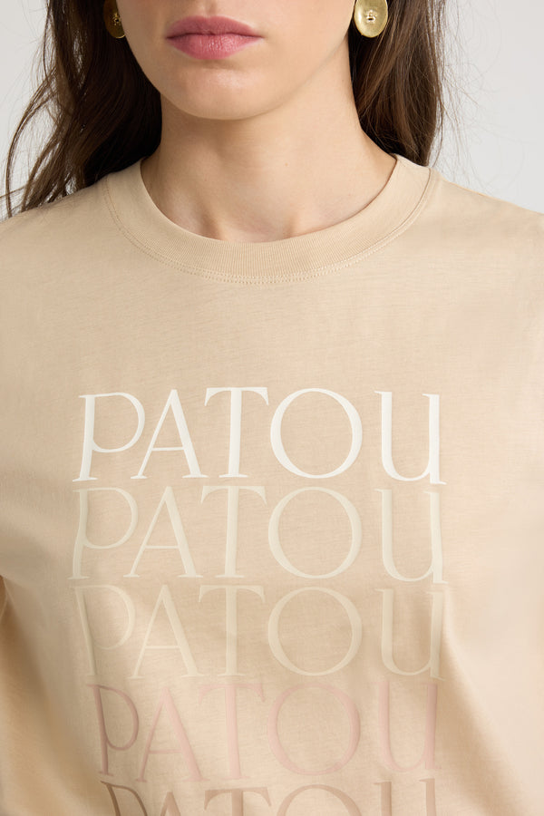 Patou - T-shirt Patou en coton bio - Praline - T-shirt en coton bio beige praline. Coupe classique. Col rond. Multiples logos Patou imprimés sur le devant avec un effet dégradé.