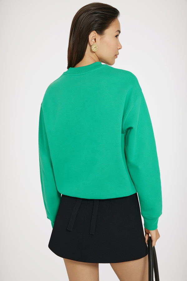 Patou - Sweatshirt JP en coton bio - Forest Green - Une signature minimaliste.Sweatshirt en coton bio vert forêt. Coupe classique. Col rond. Col, poignets et ourlet côtelés. Patch JP en bouclette à la poitrine.