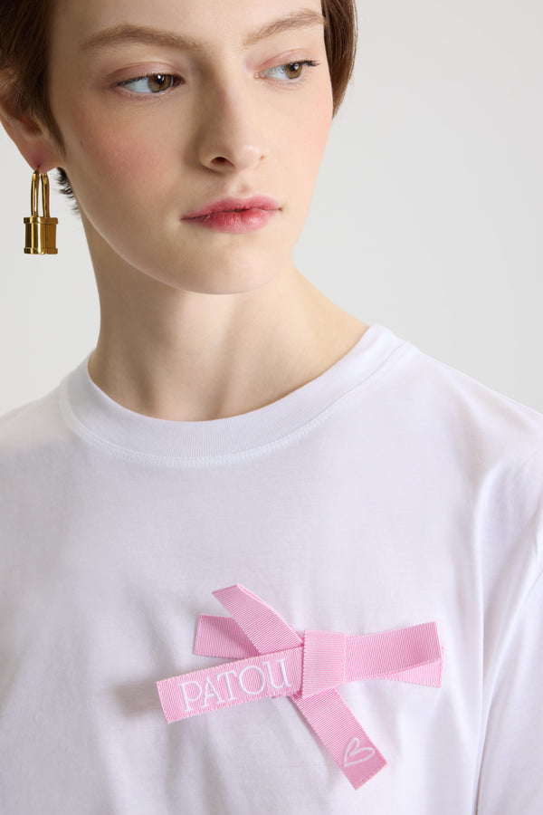 Patou - Bow t-shirt in organic cotton - Pink Pearl - White organic cotton t-shirt. Regular fit. Crewneck. Pink Pearl grosgrain bow at the chest with embroidered Patou logo and heart.