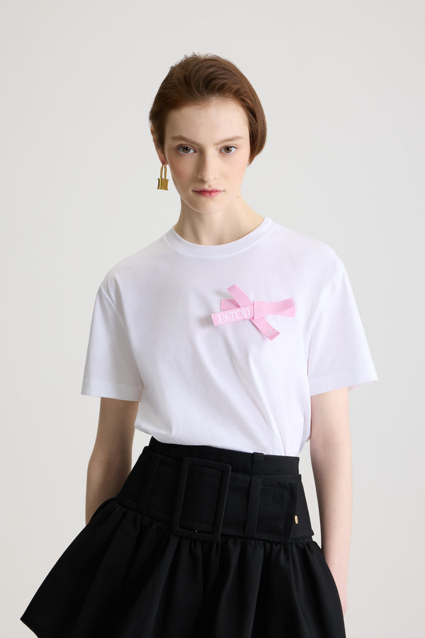 Patou - Bow t-shirt in organic cotton - Pink Pearl - White organic cotton t-shirt. Regular fit. Crewneck. Pink Pearl grosgrain bow at the chest with embroidered Patou logo and heart.