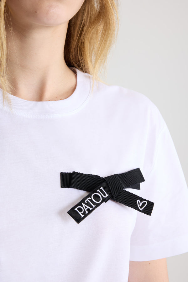 Patou - T-Shirt mit Schleife aus Bio-Baumwolle - Black - T-Shirt aus Bio-Baumwolle in Weiß. Normale Passform. Rundhalsausschnitt. Schleife aus Ripsband in Schwarz auf der Brust mit Patou Logo- und Herzstickerei.