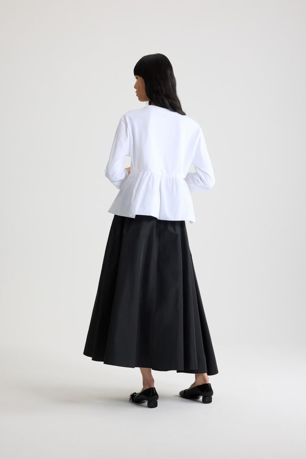 Patou - Ruffle hem t-shirt in organic cotton and faille - White - White organic cotton t-shirt. Thick jersey. Peplum silhouette with a polyester faille ruffle. Crewneck. Embroidered Patou logo at the front.