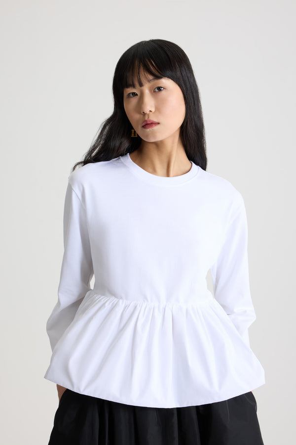 Patou - Ruffle hem t-shirt in organic cotton and faille - White - White organic cotton t-shirt. Thick jersey. Peplum silhouette with a polyester faille ruffle. Crewneck. Embroidered Patou logo at the front.