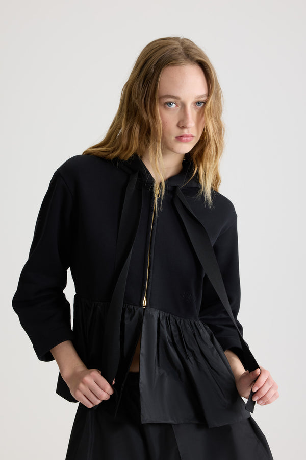 Patou - 오가닉 코튼 및 파유 소재 러플 헴 집업 후디 - Black - 블랙 컬러의 오가닉 코튼 소재. 폴리에스테르 파유 러플 디테일의 페플럼 실루엣. 그로그랭 드로우스트링 후드 칼라. 양방향 골드 톤 지퍼. 앞면의 파투 로고 자수 장식.