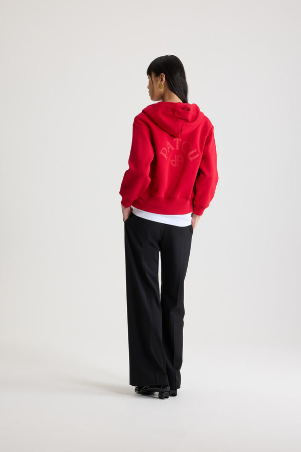 Patou - オーガニックコットンフリース パトゥロゴ＆JPモノグラム ジップアップフーディ - Scarlet Red - スカーレットレッドのオーガニックコットンフリース製フーディー。フード付き襟にグログラン ドローストリング。前面にゴールドトーンのファスナー。バックにパトゥの刺しゅうロゴとJPモノグラム。サイドポケット付き。リブ編みの袖口と裾。