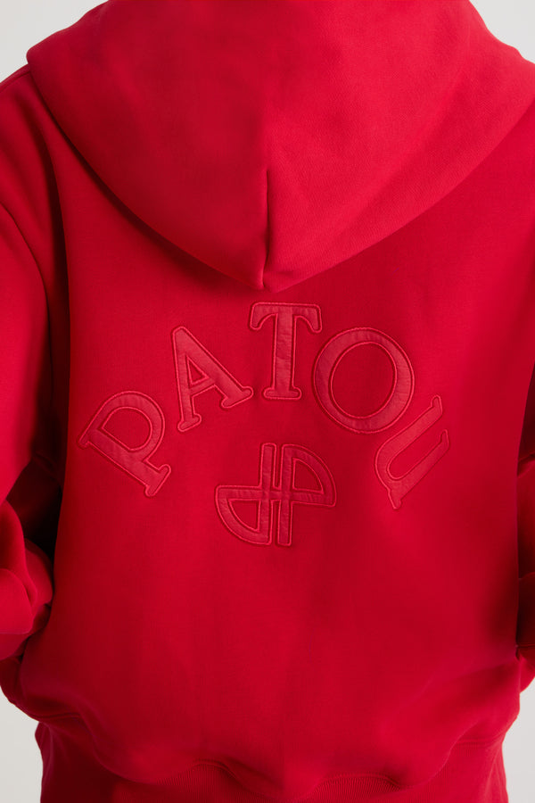 Patou - オーガニックコットンフリース パトゥロゴ＆JPモノグラム ジップアップフーディ - Scarlet Red - スカーレットレッドのオーガニックコットンフリース製フーディー。フード付き襟にグログラン ドローストリング。前面にゴールドトーンのファスナー。バックにパトゥの刺しゅうロゴとJPモノグラム。サイドポケット付き。リブ編みの袖口と裾。