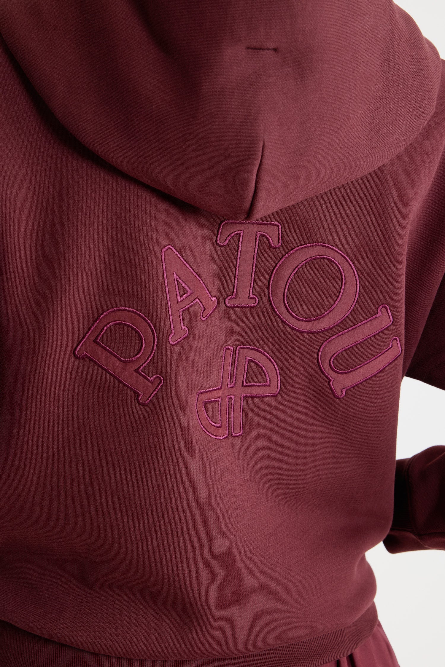 Patou - Patou logo and JP monogram zip-up hoodie in organic cotton fleece - Syrah - Syrah burgundy organic cotton fleece hoodie. Hooded collar with grosgrain drawstring. Gold-tone zip at the front. Embroidered Patou logo and JP monogram at the back. Side pockets. Ribbed cuffs and hem.