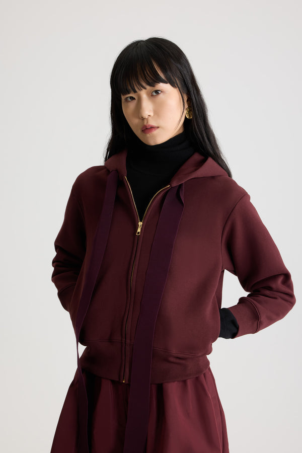 Patou - 오가닉 코튼 플리스 소재 파투 로고 및 JP 모노그램 집업 후디 - Syrah - 시라 버건디 컬러의 오가닉 코튼 플리스 후디. 그로그랭 드로우스트링 후드 칼라. 앞면의 골드 톤 지퍼. 뒷면의 JP 모노그램 및 파투 로고 자수 장식. 사이드 포켓. 립 질감 커프스 및 헴.