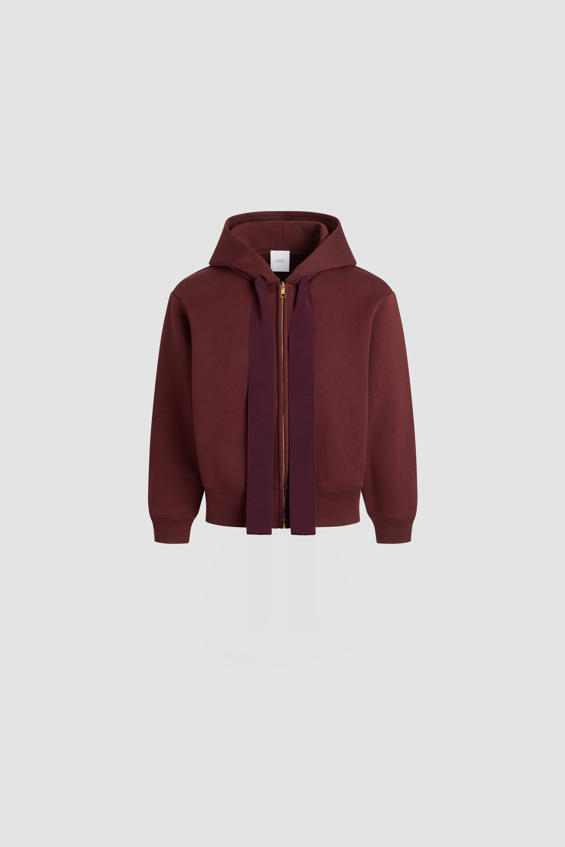 Patou - Patou logo and JP monogram zip-up hoodie in organic cotton fleece - Syrah - Syrah burgundy organic cotton fleece hoodie. Hooded collar with grosgrain drawstring. Gold-tone zip at the front. Embroidered Patou logo and JP monogram at the back. Side pockets. Ribbed cuffs and hem.