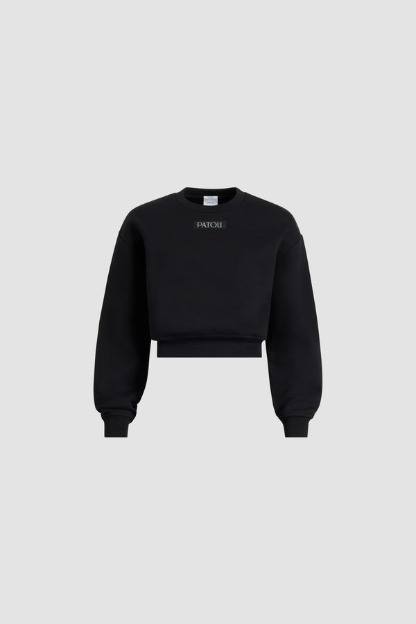 Patou - Patou logo label sweatshirt in organic cotton fleece - Black - Black organic cotton fleece sweatshirt. Slightly cropped length. Crewneck. Ribbed collar, cuffs and hem. Patou logo label sewn at the front.