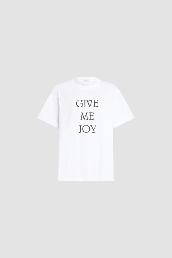 Patou - オーガニックコットン Give Me Joy Tシャツ - White - ホワイトのオーガニックコットン製Tシャツ。クルーネック、オーバーサイズスタイル。フロントにブラックのGive Me Joyゥ レタリン。ユニセックスデザイン。 男性の方は、通常着用サイズのワンサイズ上をお選びください）。