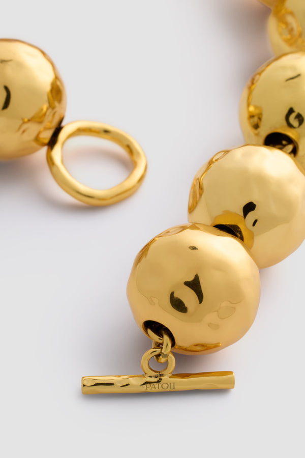 Patou - Gehämmerte Kugelhalskette aus vergoldetem Messing - Gold - Halskette aus vergoldetem Messing. Gehämmerte Kugeln. Patou als Gravur. T-Verschluss.