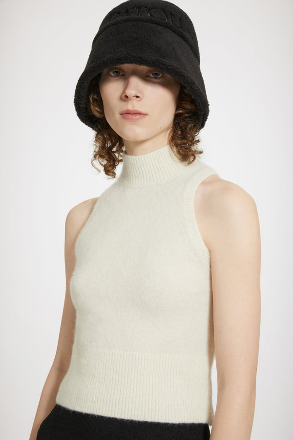 Patou - 지속 가능한 알파카 혼방 소재의 슬리브리스 탑 - Avalanche - 알파카와 함께 행복하세요.아발란체 화이트 컬러의 베이비 알파카 블렌드 탑. 몸에 밀착되는 실루엣. 슬리브리스 스타일. 하이넥 디자인. 립 처리한 칼라, 암홀, 허리 부분.밀착되는 핏 스타일.