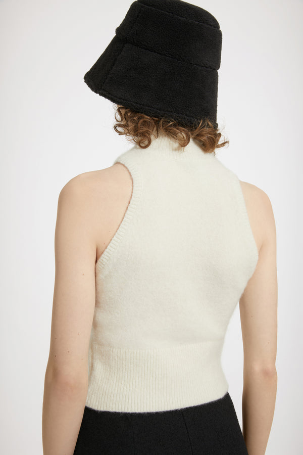 Patou - 지속 가능한 알파카 혼방 소재의 슬리브리스 탑 - Avalanche - 알파카와 함께 행복하세요.아발란체 화이트 컬러의 베이비 알파카 블렌드 탑. 몸에 밀착되는 실루엣. 슬리브리스 스타일. 하이넥 디자인. 립 처리한 칼라, 암홀, 허리 부분.밀착되는 핏 스타일.