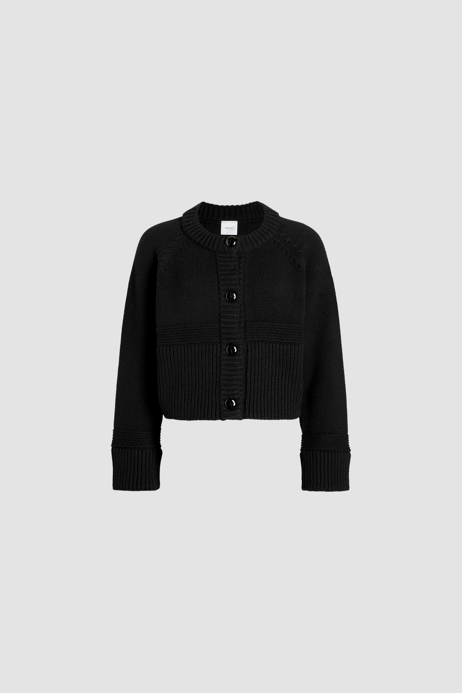 Patou - サステナブルウール＆カシミヤ ショート カーディガン - Black - ブラックのサステナブルウール＆カシミヤ製カーディガン。ミックスステッチ。ボクシーなシルエット、ややクロップド丈。ラウンドネック。カラー、袖口、裾にリブ入り。ラグランスリーブ。縫い込みレザーボタン。