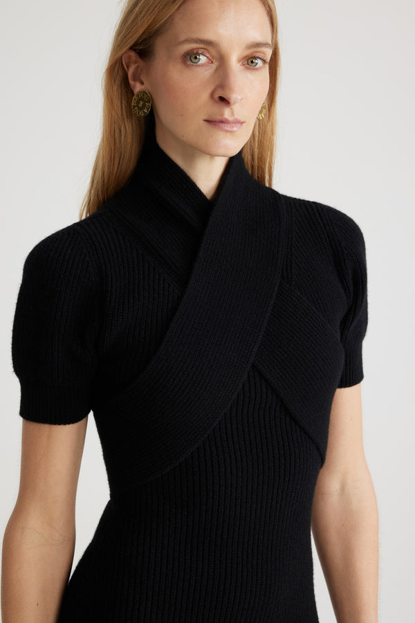 Patou - Vestito con bustino incrociato in misto lana e cachemire ecosostenibile - Black - Vestito in misto lana e cashmere ecosostenibile nero. Silhouette aderente. Collo alto. Bustino incrociato. Maniche corte. Pieghe sulla gonna.Questo modello è aderente.