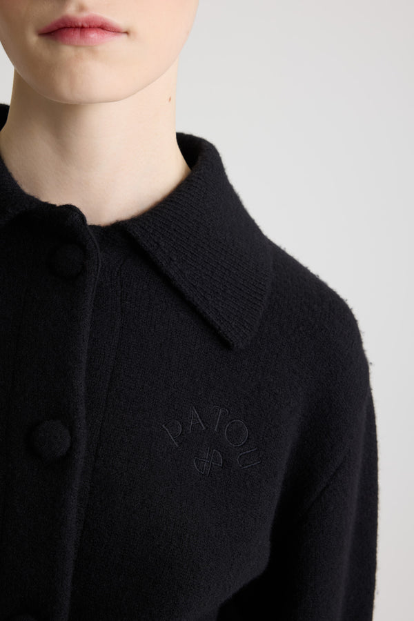 Patou - 울 소재 크롭 카디건 - Black - 블랙 컬러의 메리노 울 카디건. 크롭 길이. 셔츠 칼라. 패브릭으로 감싼 라운드 버튼 디테일의 앞면 버튼 클로저. 가슴 부분의 JP 모노그램 및 파투 로고 자수 장식. 미디 길이 벌룬 슬리브. 제트 포켓. 립 질감 커프스 및 헴.