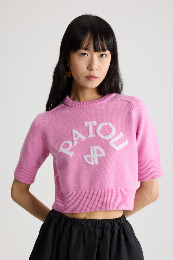 Patou - Pull court à logo Patou et monogramme JP en laine et cachemire - Pink Pearl - Pull en laine et cachemire rose perle. Modèle légèrement court. Col rond avec ruban en gros-grain à l’arrière. Logo Patou et JP contrastants en intarsia sur le devant. Manches courtes. Poignets et ourlet côtelés.