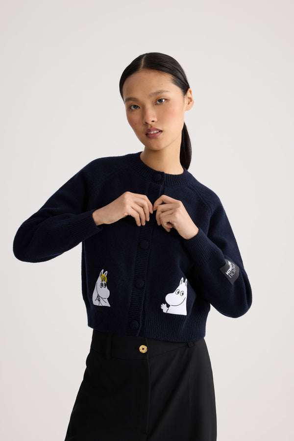 Patou - Patou x Moomin Snorkfräulein Strickjacke aus Wollgemisch - Moomin Navy - Genießen Sie die festliche Jahreszeit mit der Patou x Moomin Kollektion. Diese elegante Strickjacke zeigt Snorkfräulein auf der Vorderseite und ist aus einem hochwertigen Wollgemisch gefertigt. Die kleinen Intarsien verleihen Ihrer Garderobe einen Hauch von Laune und Nostalgie. Perfekt, um jedem Outfit eine verspielte Eleganz zu verleihen.