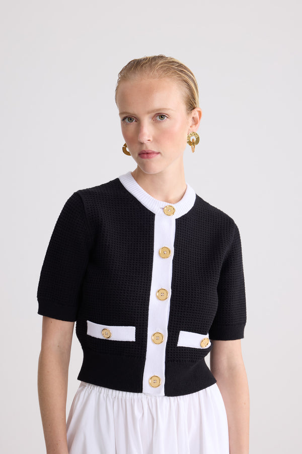 Patou - Cardigan texturé sans col en coton mélangé éco-responsable - Black - Cardigan texturé sans col noir. Manches courtes. Col rond. Bordures contrastées. Fermeture boutonnée.