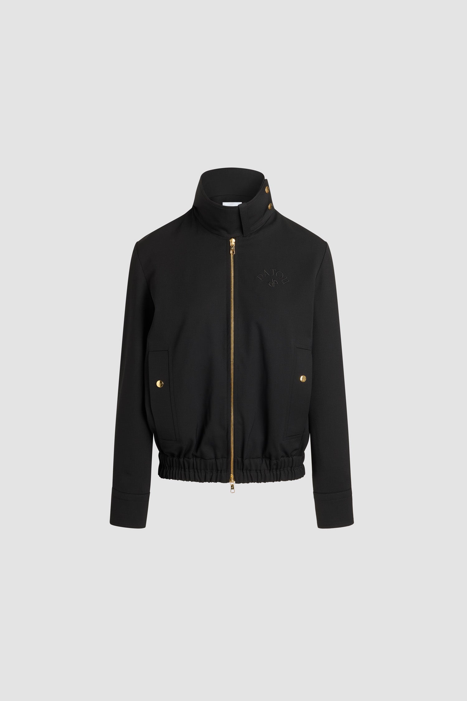 Patou - Bomber à col montant en laine technique éco-responsable - Black - Veste en sergé de laine technique éco-responsable noir. Col montant avec boucle à l’avant et boutons-pression dorés gravés du monogramme JP sur le côté. Zip doré à double curseur à l’avant. Logo Patou et monogramme JP brodés sur la poitrine. Poches verticales passepoilées avec boutons-pression dorés gravés du monogramme JP. Poignets et ourlet élastiques.