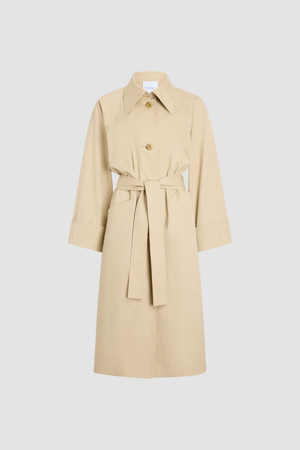 Patou - Trench-coat léger en coton bio - Safari Sand - Trench-coat léger couleur sable. Ceinture amovible à la taille. Double boutonnage doré.