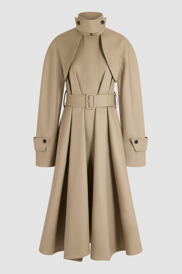 Patou - Trench en coton bio - Parchment - Trench en coton bio beige. Col montant. Fermeture boutonnée. Taille ceinturée. Volume évasé. Manches avec pattes de serrage.