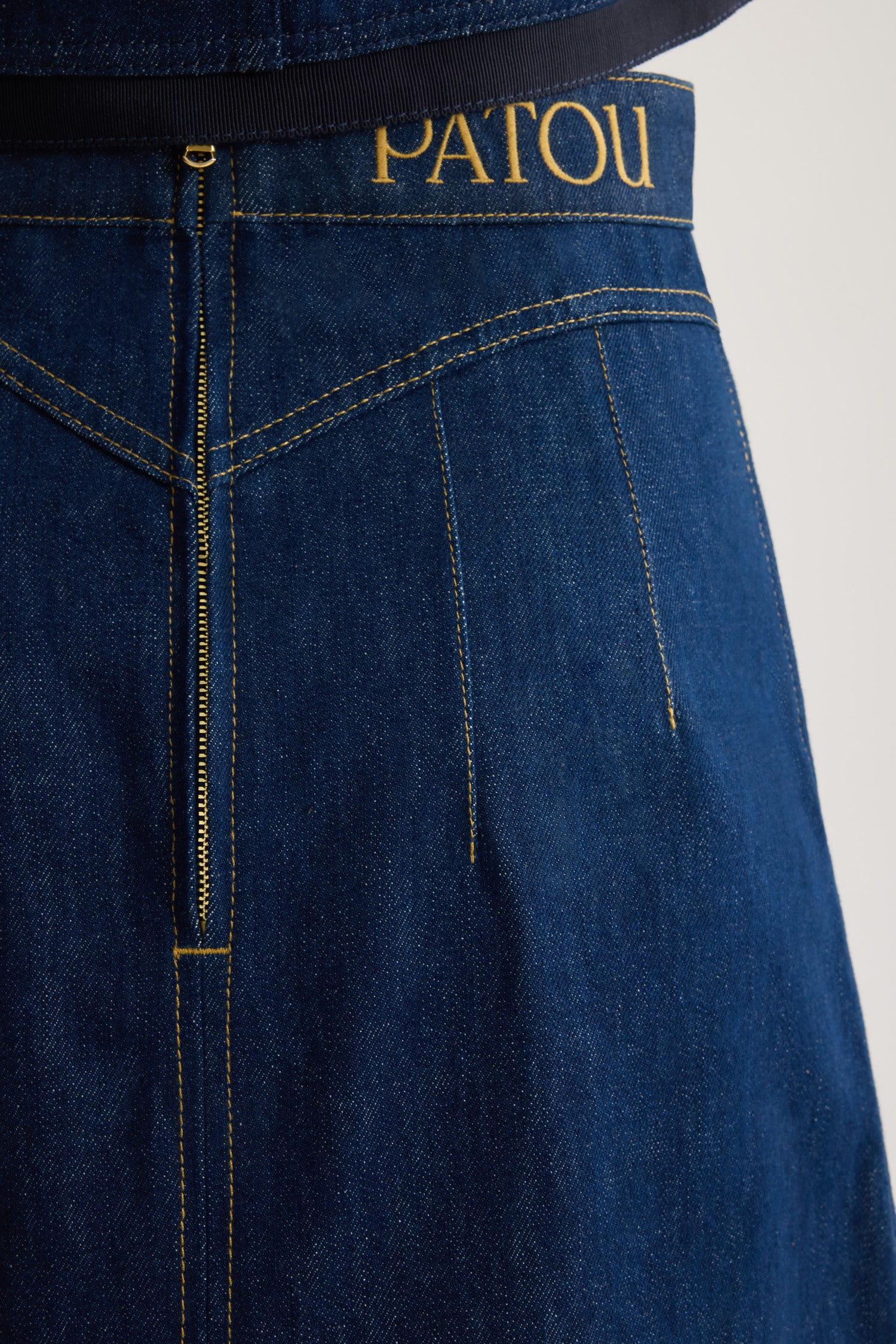 Patou - Minigonna con medaglione in denim di cotone bio - Rodeo Blue - Gonna in denim di cotone bio blu rodeo. Modello corto e svasato. Medaglione oro inciso Patou in vita. Logo Patou ricamato in vita. Due tasche sul davanti. Pinces sul davanti e sul retro. Cucitura curva sul retro e zip sul retro. Cuciture color tabacco.Fitted at the waist.The ornament can be removed.