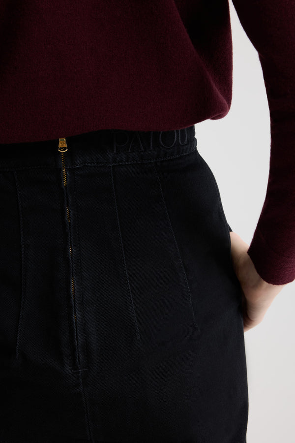 Patou - Slit midi skirt in organic cotton denim - Khol Stone - Khol Stone black organic cotton denim skirt. High waist. Midi length. Fitted silhouette with darts at the back. Removable gold-tone Patou-engraved Medallion embellishment at the front. Belt loops. High slit at the front. Pockets at the sides. Zip fastening at the back. Embroidered Patou at the waist.This style is fitted at the waist.