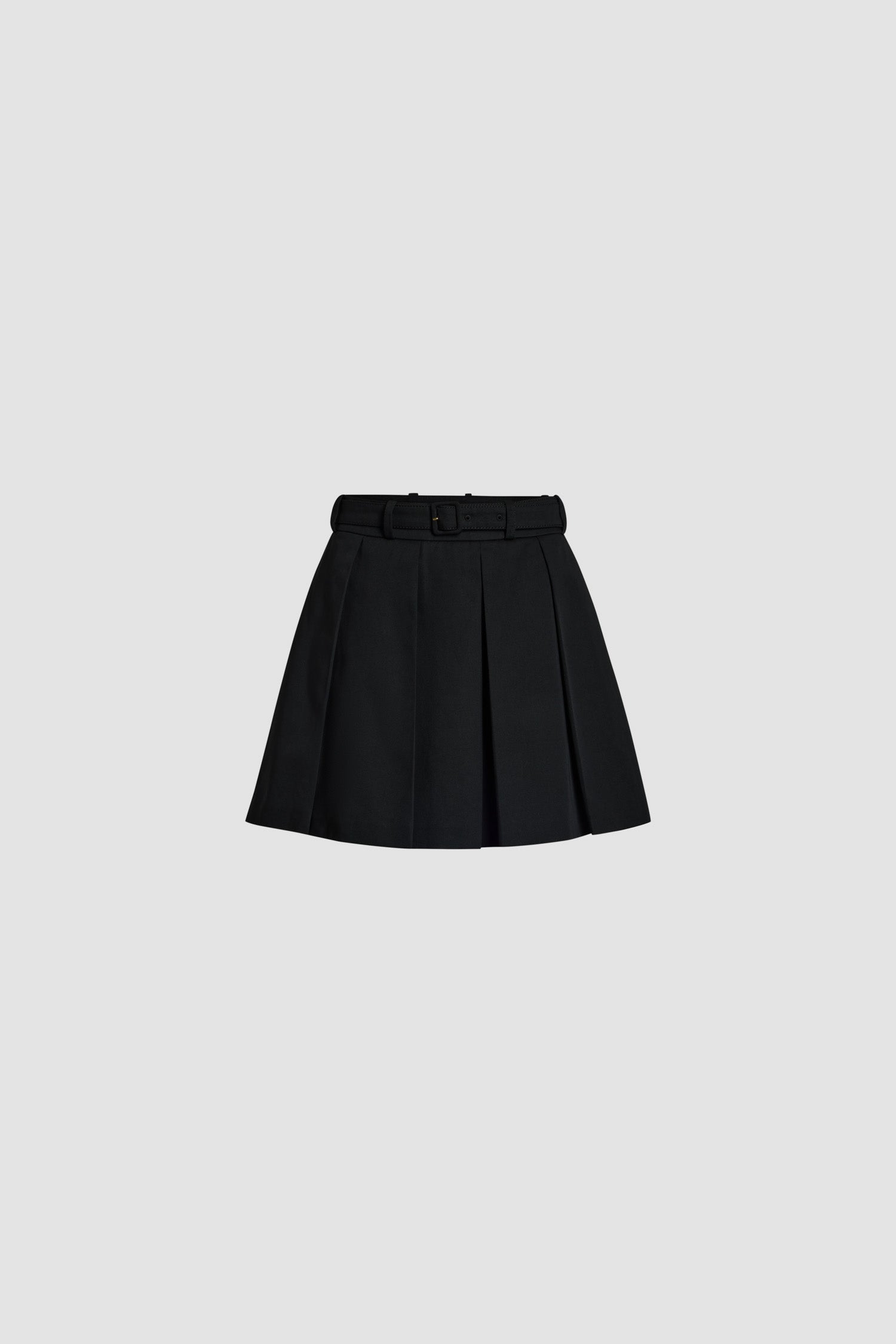 Patou - Pleated mini skirt in organic cotton - Black - Black organic cotton gabardine skirt. Short length. Wide box pleats. Removable belt with adjustable buckle. Belt loops. Pockets at the sides. Zip fastening at the back.