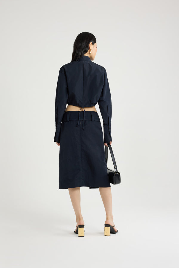 Patou - Belted midi skirt in lightweight recycled nylon - Navy Black - Navy Black lightweight recycled nylon skirt. Midi length. Low waist. Removable wide fabric belt. High slit at the front. Zip fastening at the back. Lined.