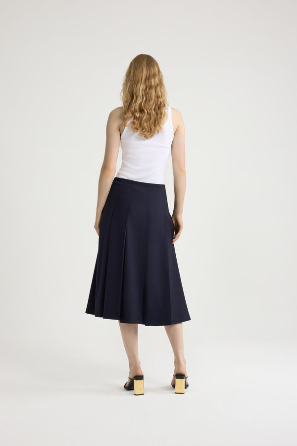 Patou - Pleated midi skirt in sustainable technical wool twill - Navy Black - Navy Black sustainable technical wool twill skirt. Midi length. Grosgrain trim at the waist. Wide pleats. Zip fastening at the side.