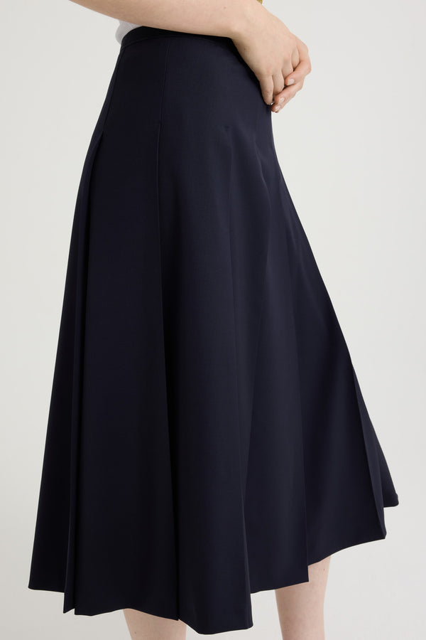 Patou - Pleated midi skirt in sustainable technical wool twill - Navy Black - Navy Black sustainable technical wool twill skirt. Midi length. Grosgrain trim at the waist. Wide pleats. Zip fastening at the side.