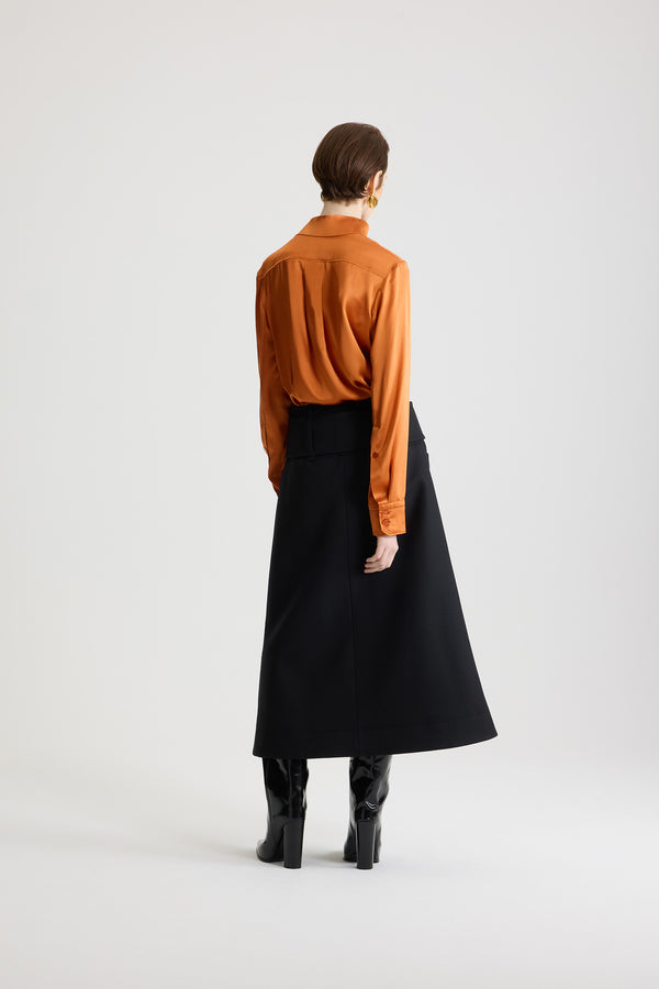 Patou - Jupe midi ceinturée zippée à l’avant en laine - Black - Jupe en laine vierge noire. Longueur midi. Taille basse. Fermeture par zip doré à double curseur à l’avant. Ceinture large en tissu sur les hanches avec boucle recouverte de tissu et anneau doré. Poches basses sur le devant.