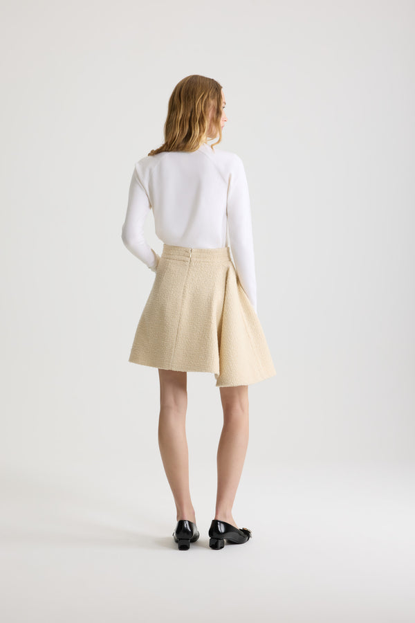 Patou - Asymmetric mini skirt in sustainable wool blend tweed - Snowberry White - Snowberry White sustainable wool blend tweed skirt. Short length. Mid waist. Asymmetric silhouette with pleating on one side. Zip fastening at the back. Single rounded pocket at the side. Lined.