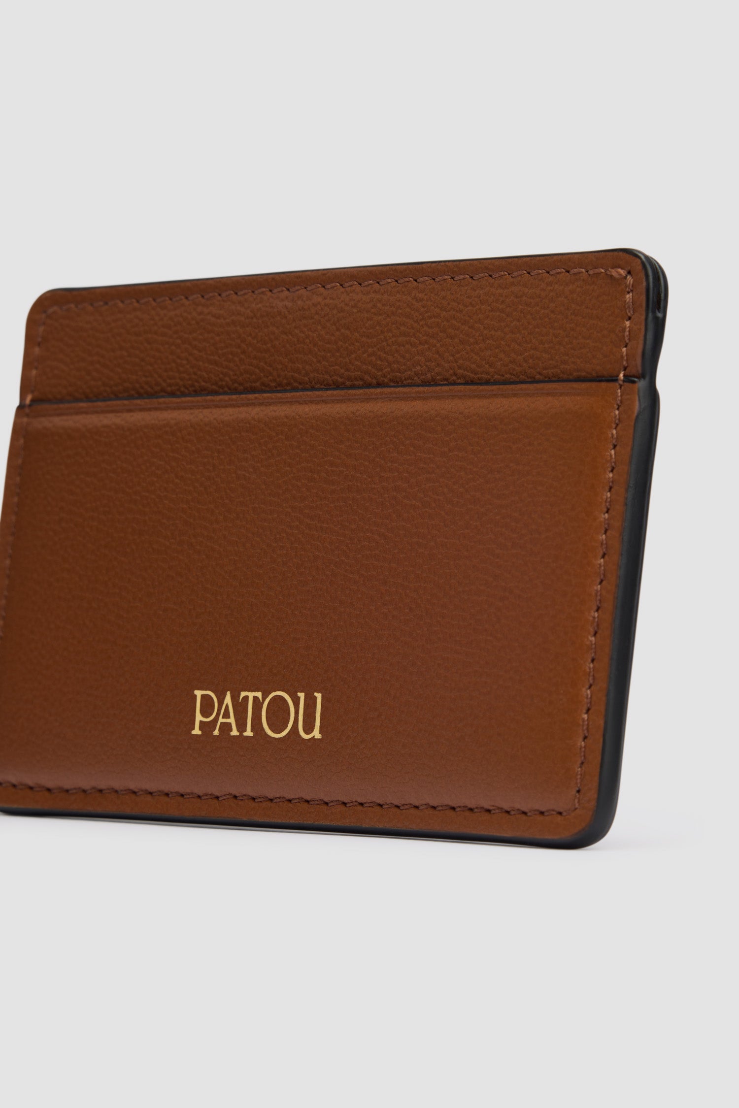 Patou - JP cardholder in leather - Black Chestnut - Black Chestnut two-tone leather cardholder. Two card slots, central compartment. Gold embossed Patou at the front, cut-out at the back.