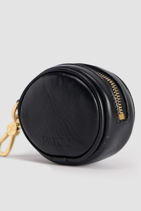 Patou - Mini JP pouch in leather - Black - Black leather pouch. Crafted using unique materials sourced from unused high-quality leather hides. Can be used as a bag charm. Oval shape with a foam-padded 3D JP monogram at the front. Embossed Patou at the back. Zip fastening. Gold-tone hook. Designed to fit wireless earphones.