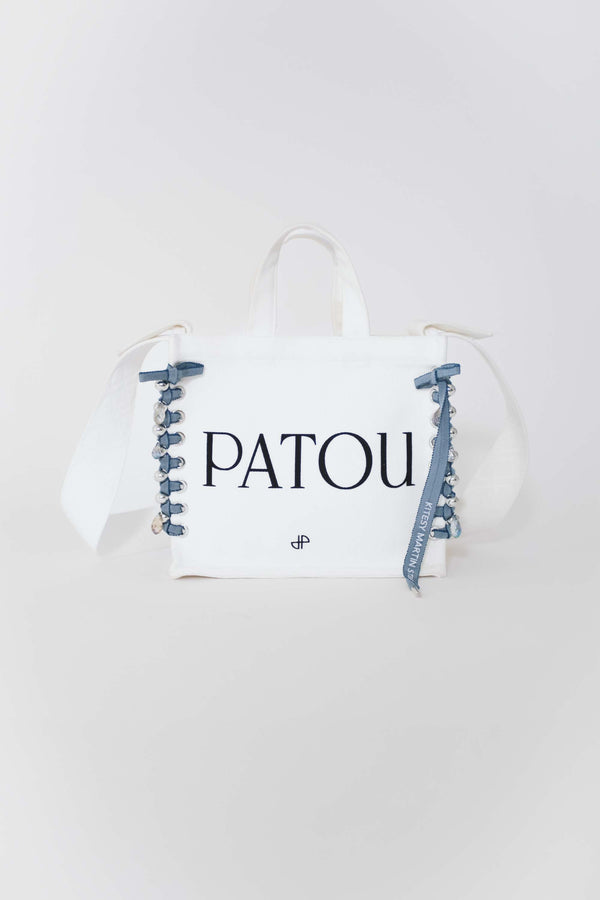 Patou - Patou Upcycling borsa tote in cotone bio - Aurora - For its inaugural edition, Patou partners with French designer Kitesy Martin, founder of Kitesy Martin Studio.Borse tote in cotone bio color panna. Logo Patou e monogramma JP neri. Tracolla bianca con disegni JP in rilievo; bottone oro. Doppia maniglia. Può essere indossata in spalla o portata a mano.Limited Edition.