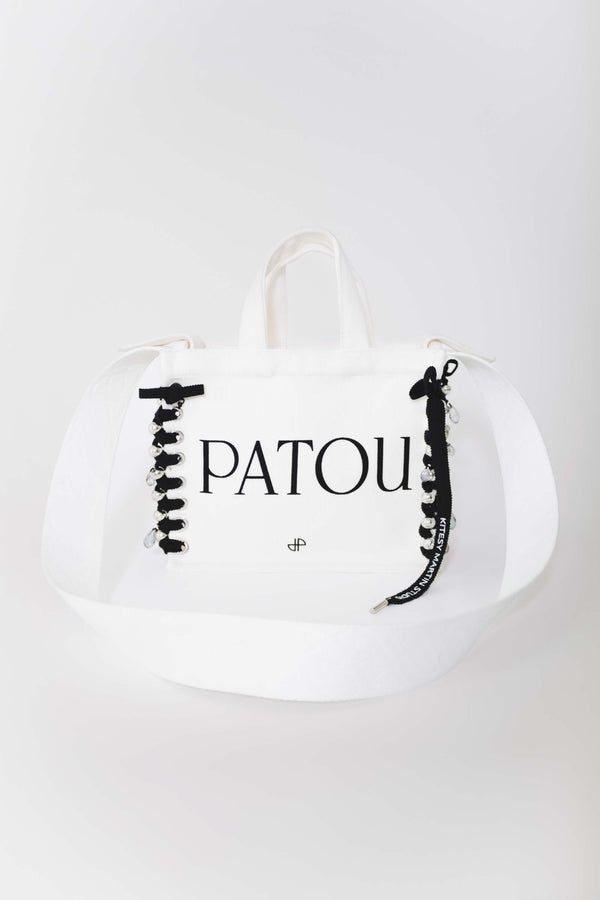 Patou - Patou Upcycling borsa tote in cotone bio - Black - For its inaugural edition, Patou partners with French designer Kitesy Martin, founder of Kitesy Martin Studio.Borse tote in cotone bio color panna. Logo Patou e monogramma JP neri. Tracolla bianca con disegni JP in rilievo; bottone oro. Doppia maniglia. Può essere indossata in spalla o portata a mano.Limited Edition.