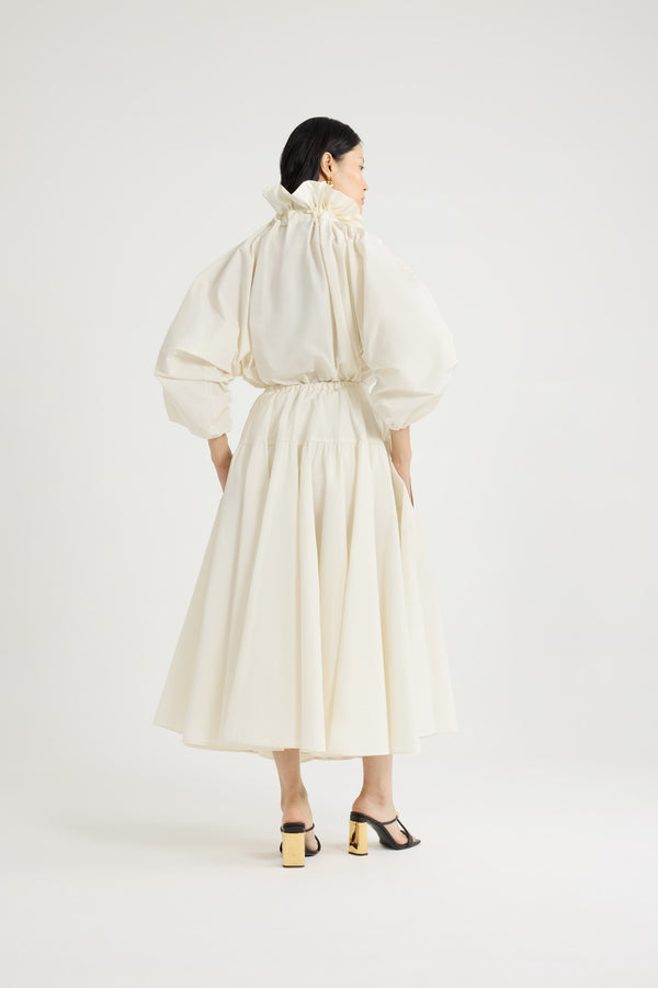 Patou - Haut à manches bouffantes en faille recyclée - Ivory - Haut en faille recyclée ivoire. Silhouette volumineuse. Col à coulisse avec détail de fronce et gros-grain. Manches chauve-souris resserrées aux poignets. Taille élastiquée.Ce top fait partie de la collection Cérémonie créée pour les occasions spéciales.