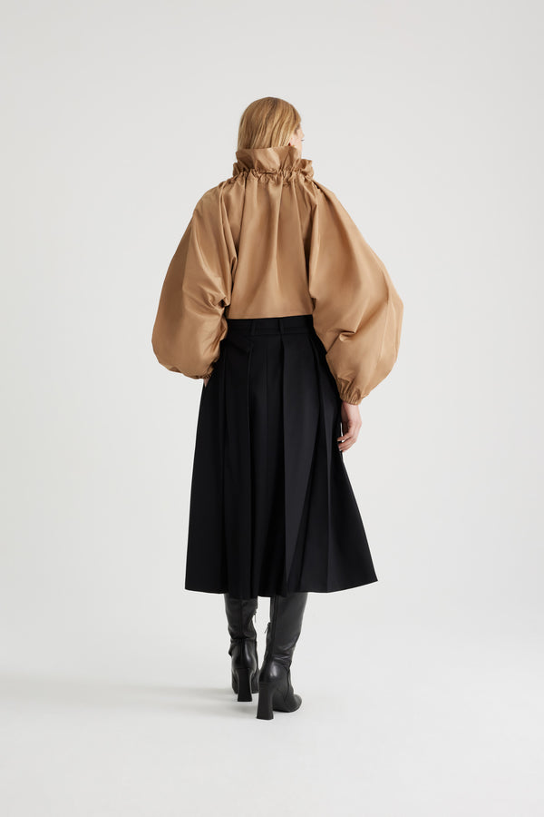 Patou - 재생 파유 아이코닉 드로우스트링 탑 - Gray Sand - 그레이 샌드 컬러의 재생 폴리에스터 파유 소재. 목 부분에서 매듭 짓거나 오프 숄더 스타일로 연출할 수 있는 볼륨감 있는 실루엣. 앞면의 플라운스 주름을 넣은 드로우스트링 칼라, 긴 그로그랭 타이. 신축성 있는 커프스의 배트윙 슬리브. 신축성 있는 허리 부분.