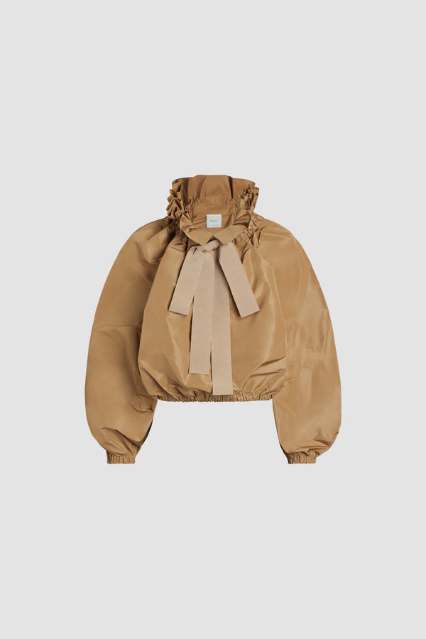 Patou - 재생 파유 아이코닉 드로우스트링 탑 - Gray Sand - 그레이 샌드 컬러의 재생 폴리에스터 파유 소재. 목 부분에서 매듭 짓거나 오프 숄더 스타일로 연출할 수 있는 볼륨감 있는 실루엣. 앞면의 플라운스 주름을 넣은 드로우스트링 칼라, 긴 그로그랭 타이. 신축성 있는 커프스의 배트윙 슬리브. 신축성 있는 허리 부분.