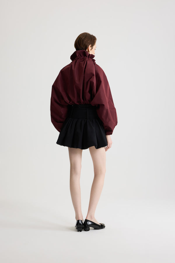 Patou - La Patou Blouse リサイクルファイユ - Vignola - ヴィニョーラマルーンのリサイクルポリエステルファイユ製トップス。ネックで結んでもオフショルダーでも着用可能なハイボリューム シルエット。フロントにフラウンスをあしらったドローストリングカラー、ロンググログランタイ付き。袖口に伸縮性があるバットウィングスリーブ。伸縮性があるウエスト。