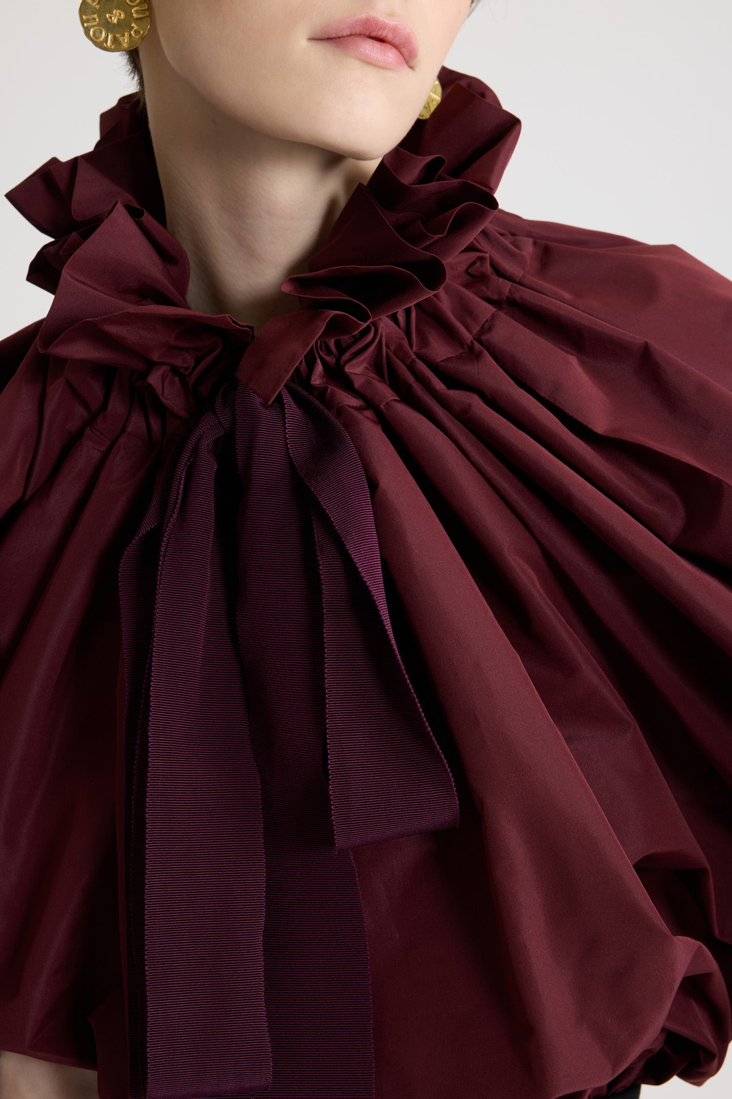 Patou - Haut iconique à coulisse en faille recyclée - Vignola - Haut en faille de polyester recyclé bordeaux Vignola. Silhouette très volumineuse pouvant être portée nouée au cou ou avec les épaules dénudées. Col à coulisse avec fronce à l’avant et longs liens en gros-grain. Manches chauve-souris avec poignets élastiques. Taille élastique.
