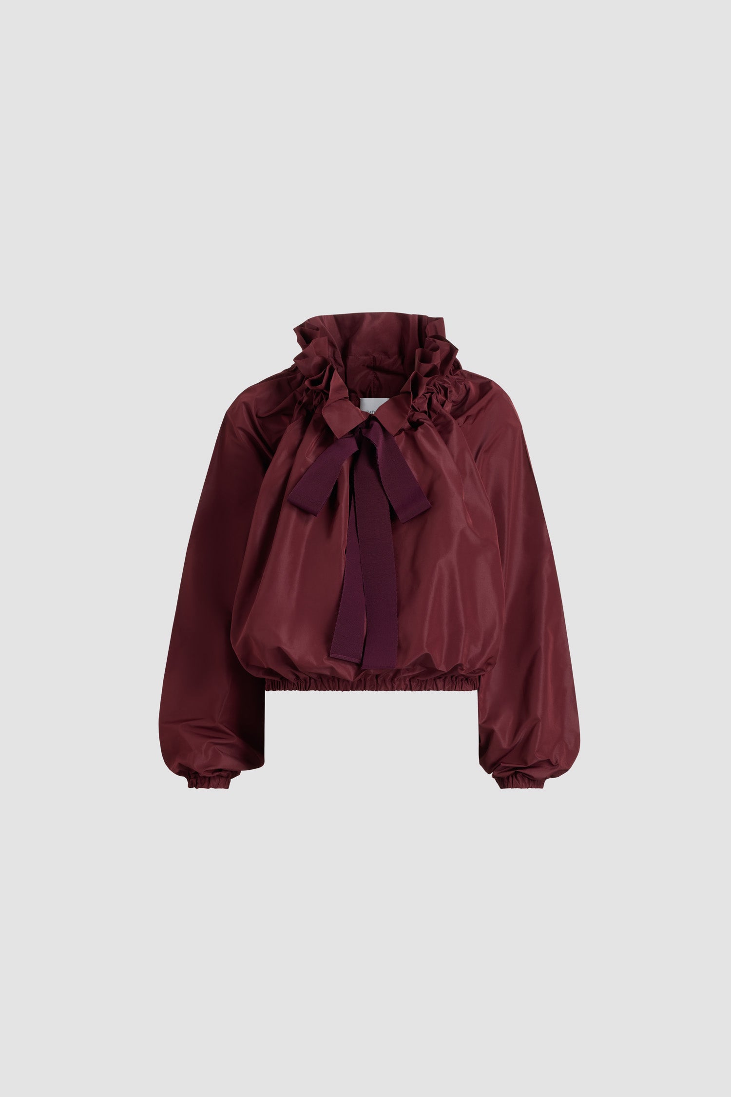 Patou - Haut iconique à coulisse en faille recyclée - Vignola - Haut en faille de polyester recyclé bordeaux Vignola. Silhouette très volumineuse pouvant être portée nouée au cou ou avec les épaules dénudées. Col à coulisse avec fronce à l’avant et longs liens en gros-grain. Manches chauve-souris avec poignets élastiques. Taille élastique.