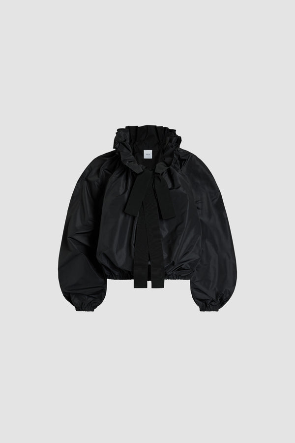 Patou - La Patou Blouse en faille recyclée - Black - Blouse en faille de polyester noire. Silhouette volumineuse. Col à coulisse avec détail de fronce et grosgrain. Manches chauve-souris resserrées aux poignets. Taille élastiquée.