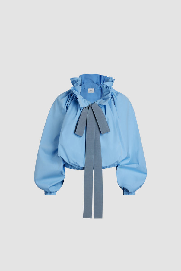 Patou - Iconic drawstring top in organic cotton - Airy Blue - Airy Blue organic cotton poplin top. High volume silhouette that can be worn knotted at the neck or off the shoulders. Drawstring collar with flounce at the front and long grosgrain ties. Batwing sleeves with elasticated cuffs. Elasticated waist.