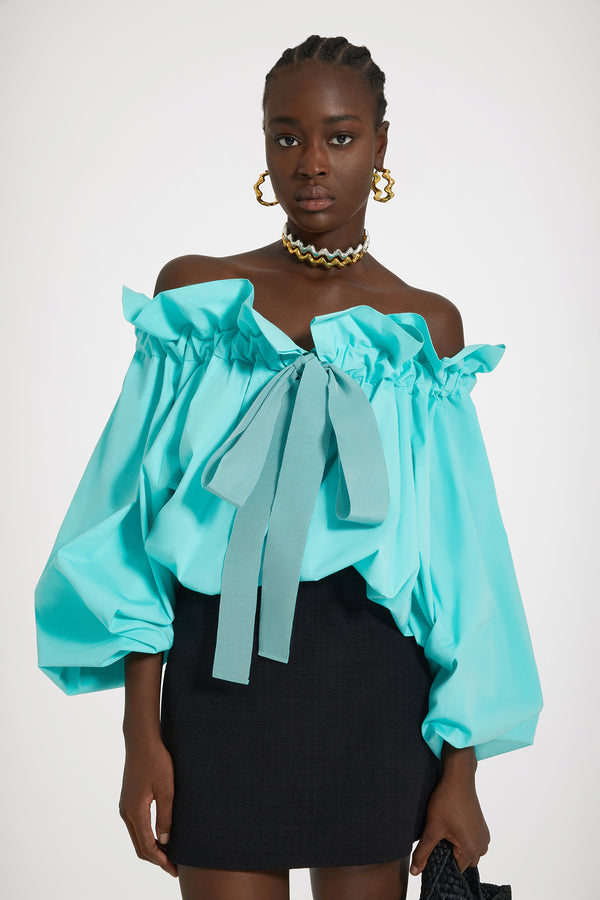 Patou - 지속 가능한 코튼 아이코닉 드로우스트링 탑 - Mint Green - 파투 아이콘의 진정한 베리에이션.민트 그린 컬러의 지속 가능한 코튼 포플린 소재. 목 부분에서 매듭 짓거나 오프 숄더 스타일로 연출할 수 있는 볼륨감 있는 실루엣. 앞면의 플라운스 주름을 넣은 드로우스트링 칼라, 긴 그로그랭 타이. 신축성 있는 커프스의 배트윙 슬리브. 신축성 있는 허리 부분.