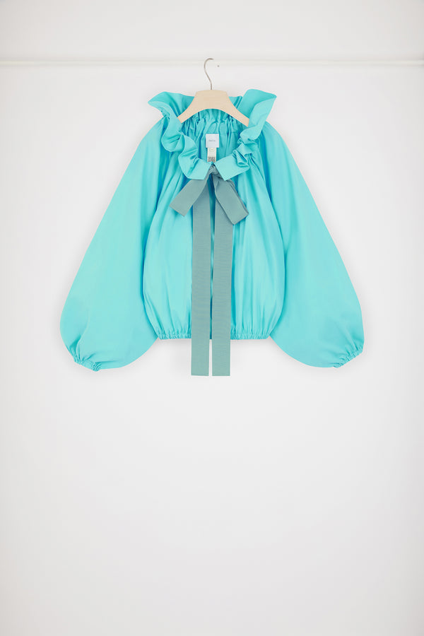 Patou - 지속 가능한 코튼 아이코닉 드로우스트링 탑 - Mint Green - 파투 아이콘의 진정한 베리에이션.민트 그린 컬러의 지속 가능한 코튼 포플린 소재. 목 부분에서 매듭 짓거나 오프 숄더 스타일로 연출할 수 있는 볼륨감 있는 실루엣. 앞면의 플라운스 주름을 넣은 드로우스트링 칼라, 긴 그로그랭 타이. 신축성 있는 커프스의 배트윙 슬리브. 신축성 있는 허리 부분.